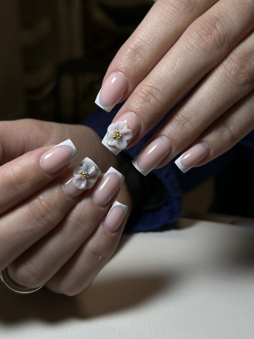 French manucure blanche avec fleurs 3D et perles dorées